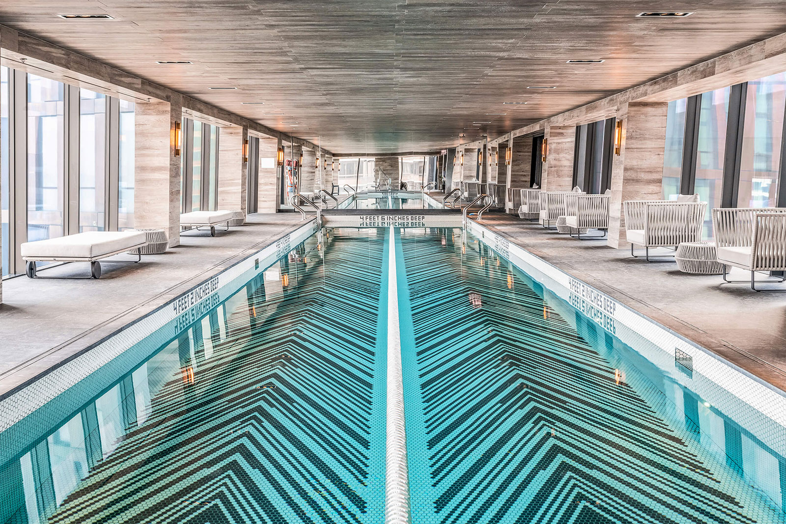 Beautiful indoor lap pool with seating located at The Copper, luxury apartments for rent in Murray Hill.