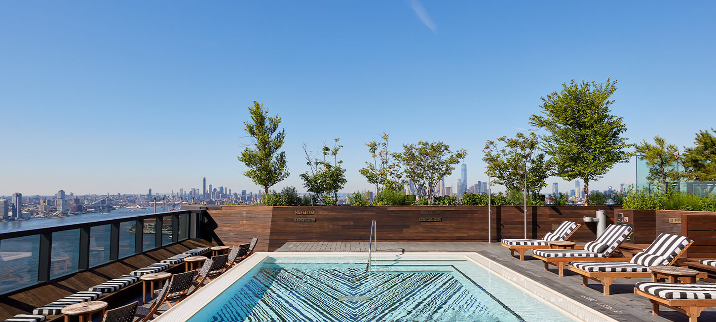 Luxury AYRE rooftop pool at The Copper apartments in NYC, offering residents a serene space with stunning skyline views.