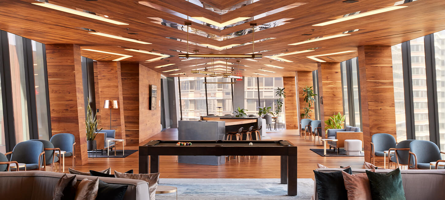 Modern residential lounge with pool table and Manhattan views at The Copper, luxury apartments for rent in Murray Hill.