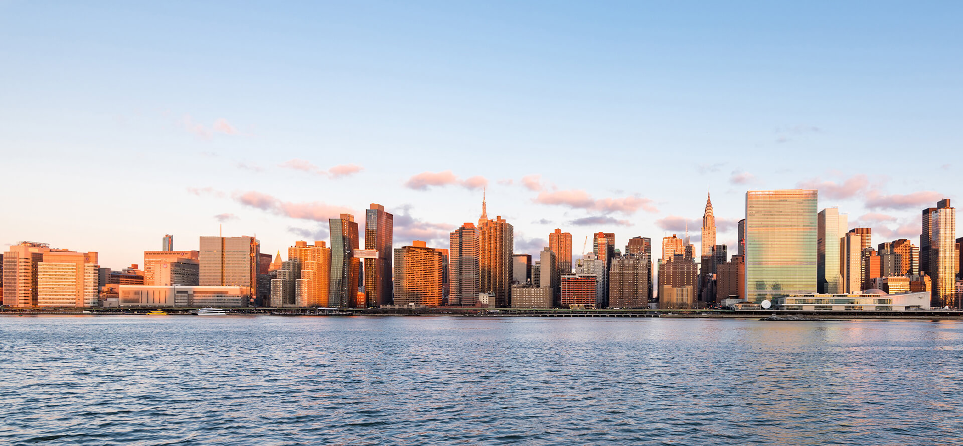  Stunning view of The Copper apartments on the NYC skyline along East River, showcasing waterfront living in Murray Hill.