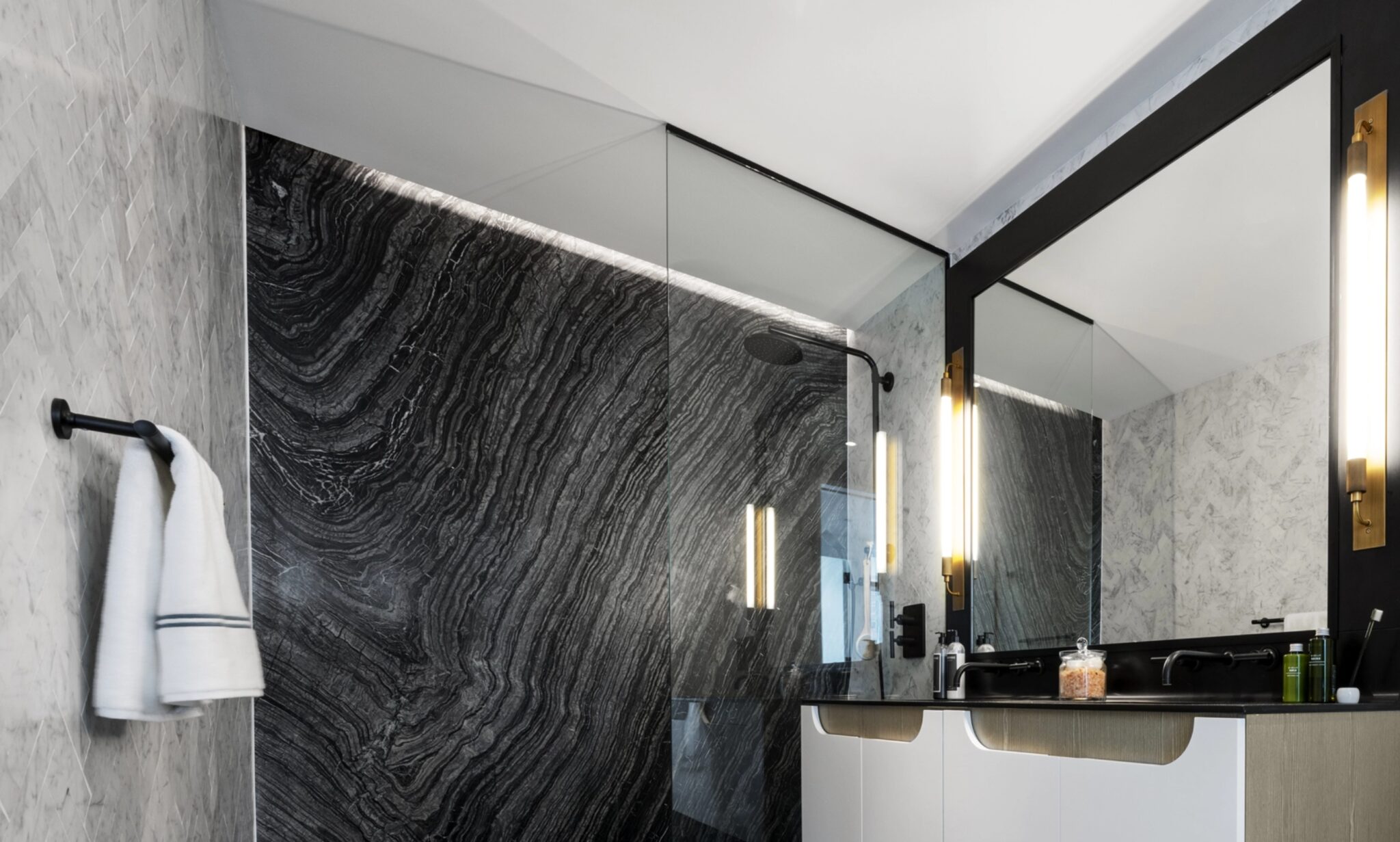 Gorgeous bathroom at The Copper in Murray Hill featuring a rain shower, modern finishes, and a stunning marble wall.