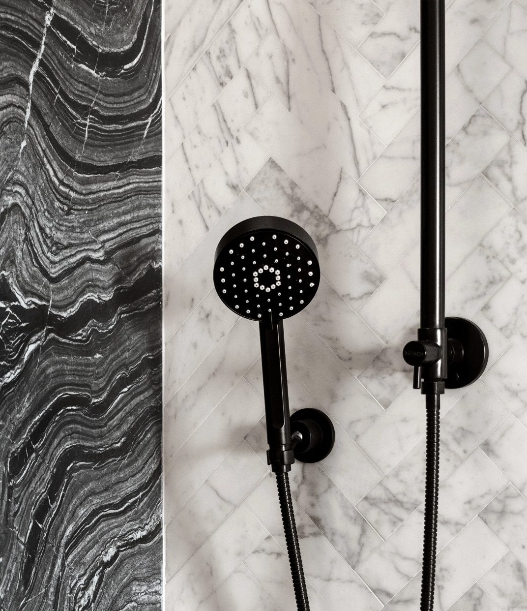 Beautiful rain shower with detachable handheld spray and marble wall at The Copper apartments in Murray Hill.