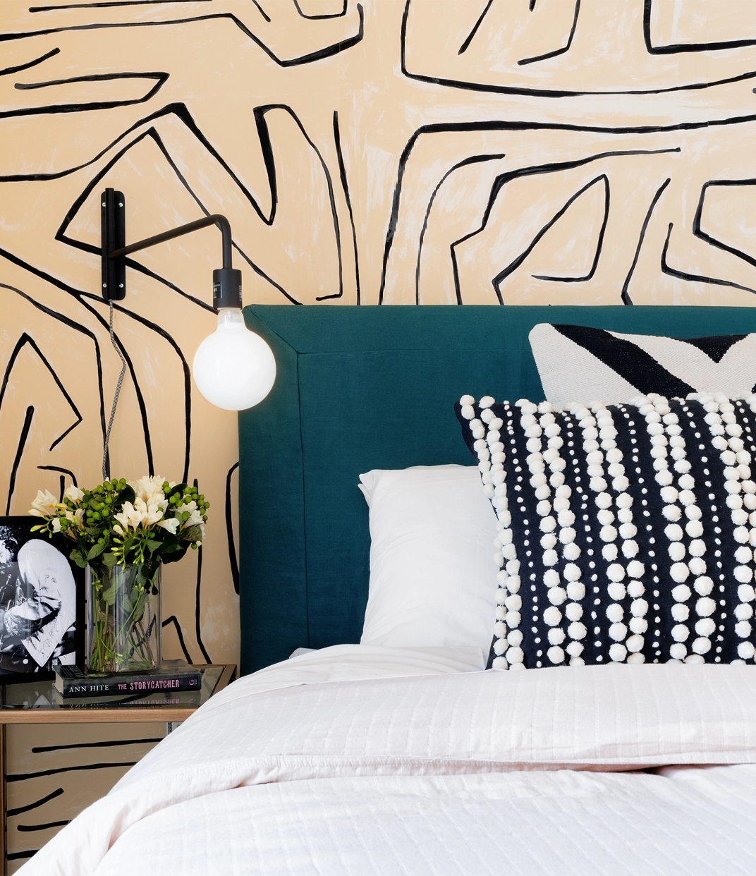 Cozy bedroom at The Copper in Murray Hill featuring stylish wallpaper and a comfortable bed for a modern, inviting space.