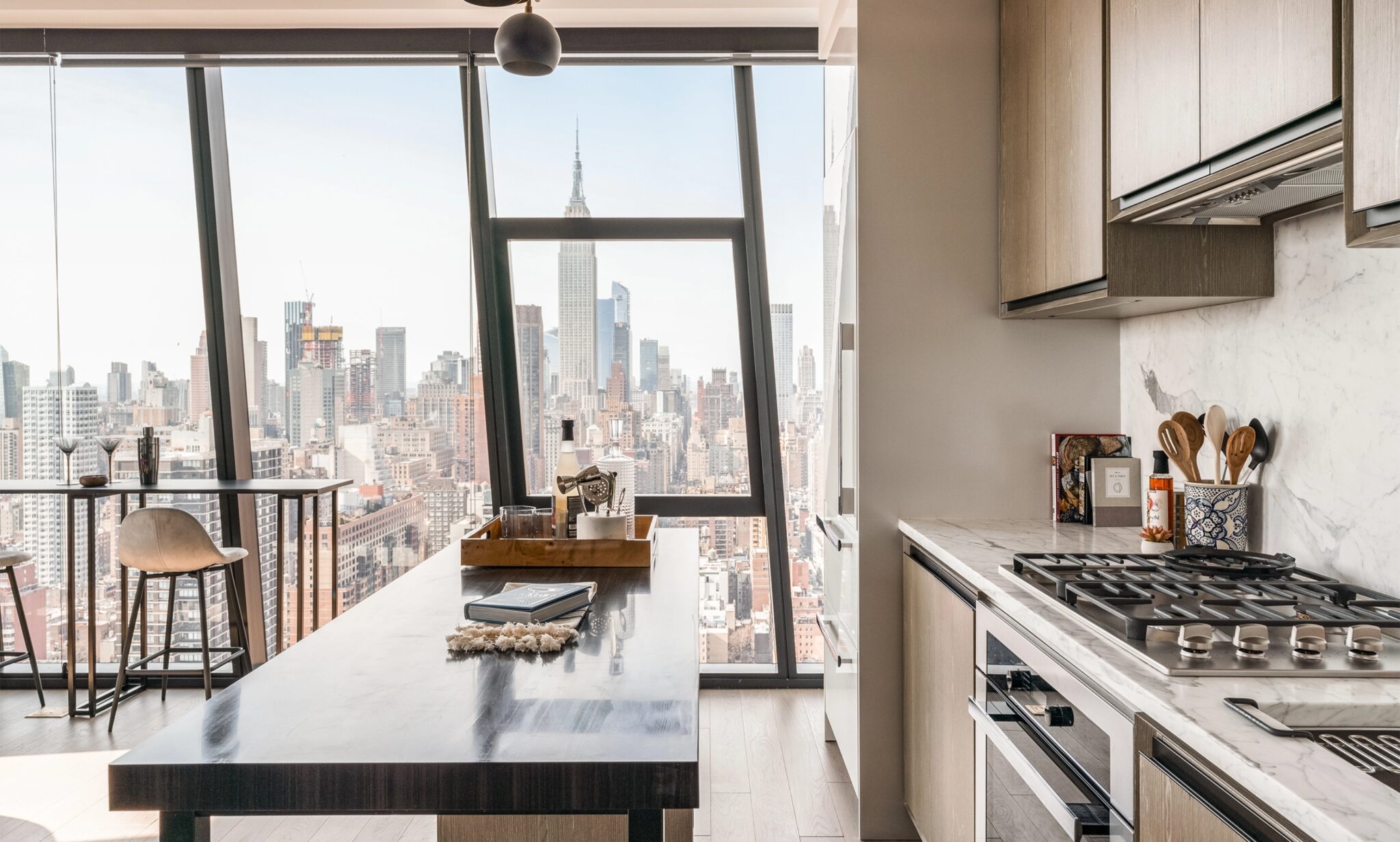 Luxury apartment at The Copper in Murray Hill featuring an island and floor-to-ceiling windows with stunning Manhattan views.