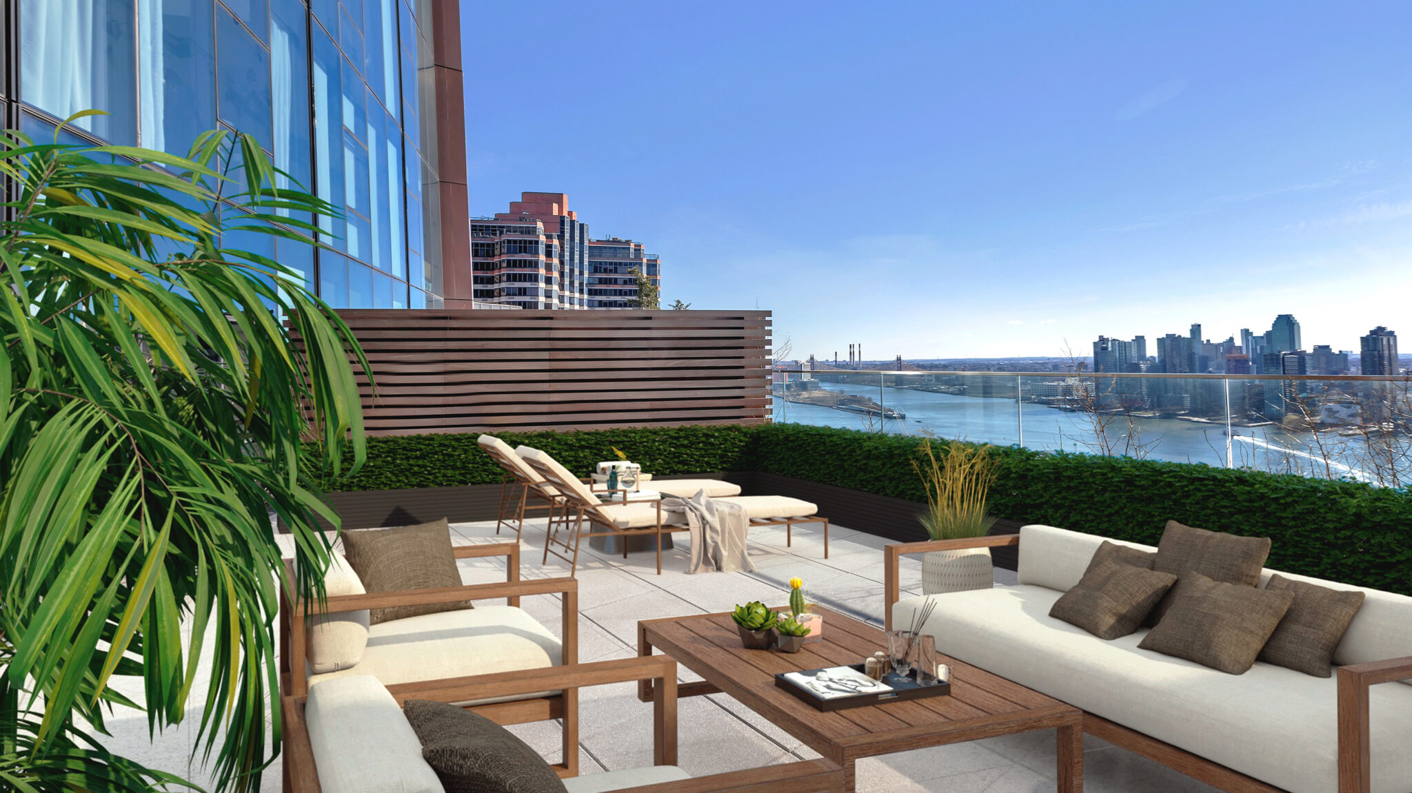 Luxury outdoor terrace at The Copper apartments in Murray Hill featuring seating & lounge chairs with beautiful water views.