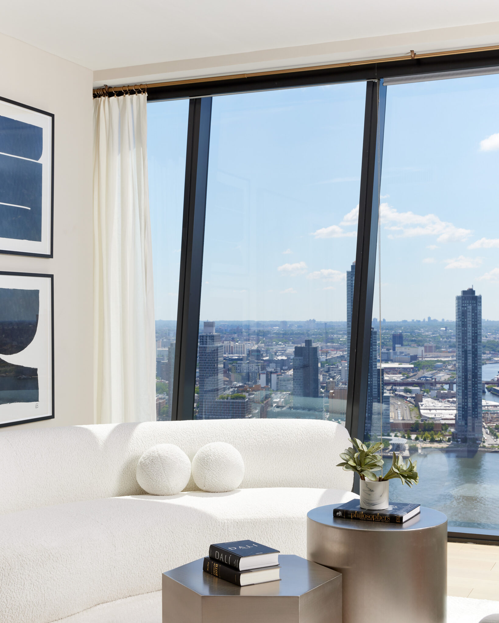 Modern living room at The Copper apartments in Murray Hill with white couch and stunning views of the East River.