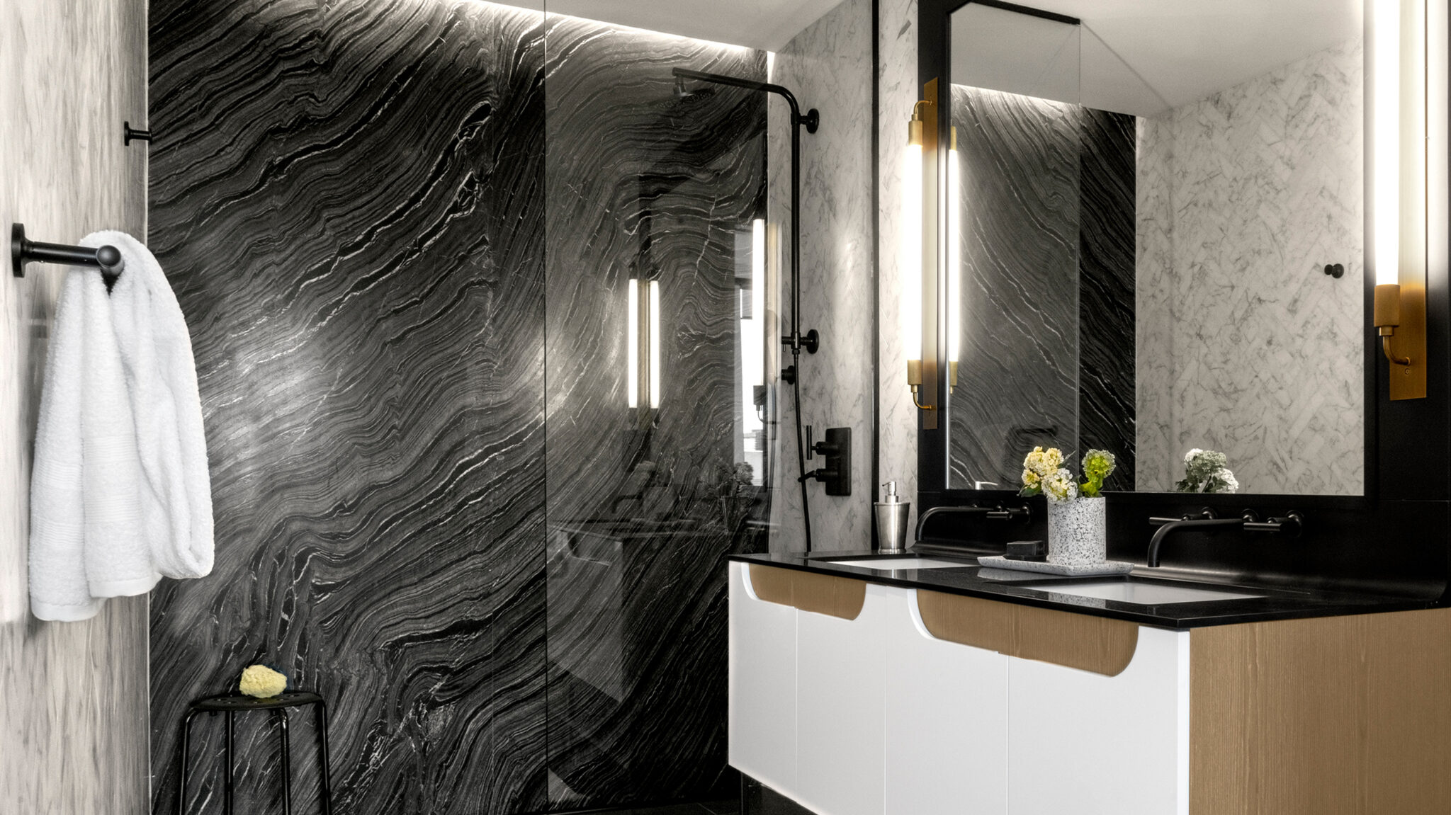 Stunning modern bathroom at The Copper apartments in Murray Hill featuring a marble wall, double sinks, and a rain shower.