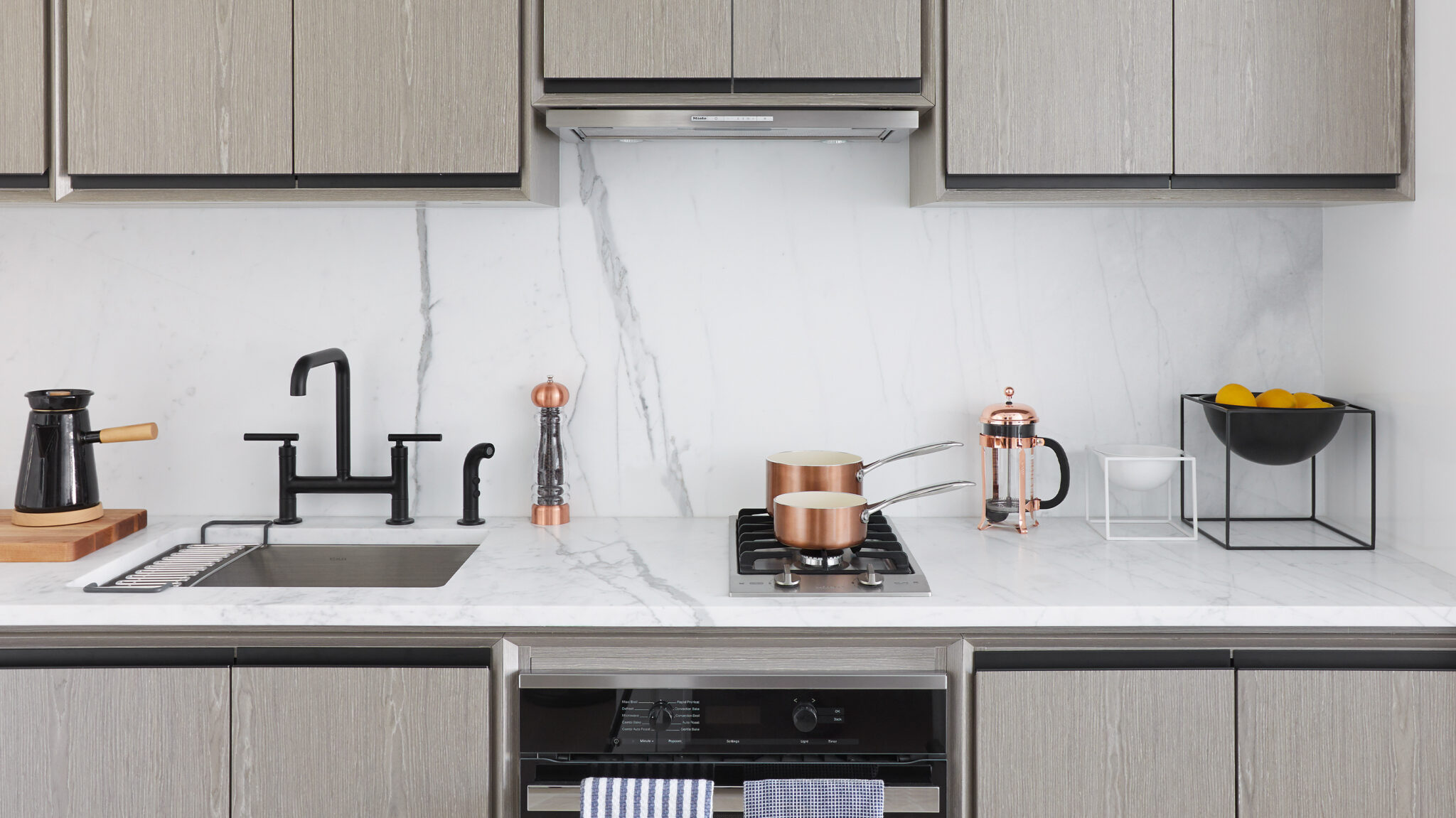 Sleek, modern white marble kitchen with stainless steel appliances at a luxury rental in Murray Hill at The Copper NYC.