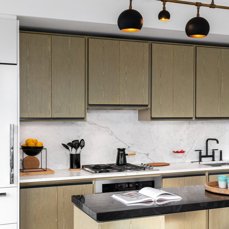 Modern kitchen at The Copper apartments in Murray Hill, featuring a spacious island and marble backsplash for luxury living.
