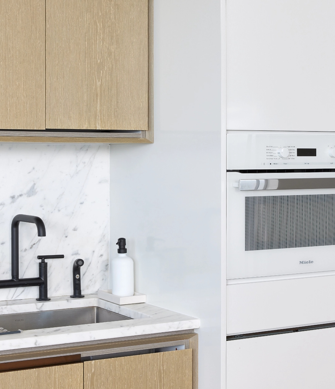 Gorgeous modern kitchen at The Copper apartments in Murray Hill featuring a white marble backsplash and natural light.
