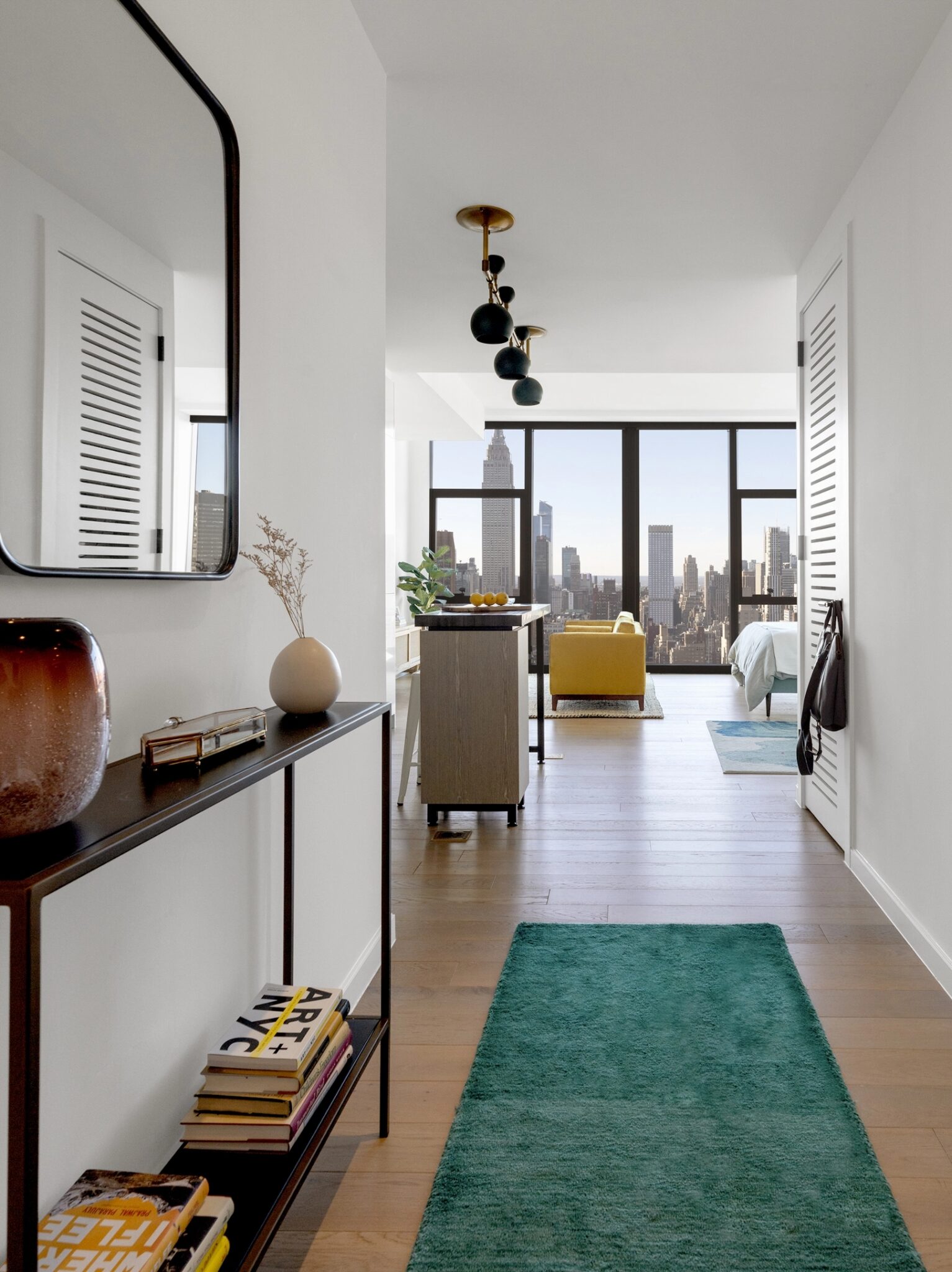 Modern studio at The Copper in Murray Hill with hardwood floors and floor-to-ceiling windows showcasing stunning city views.