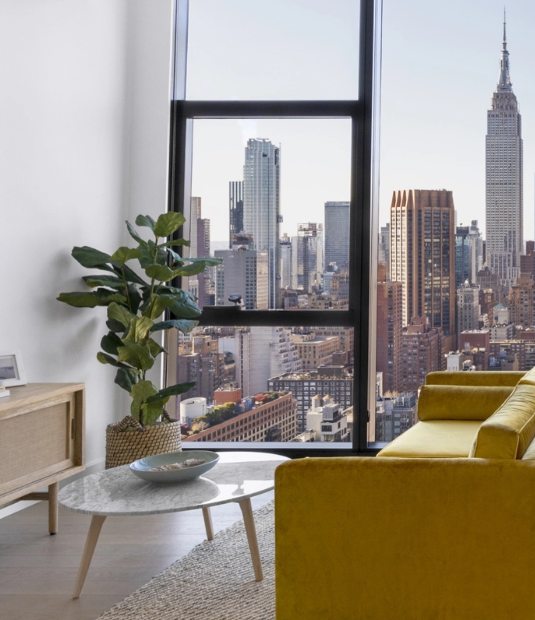 Modern apartment at The Copper in Murray Hill with hardwood floors and floor-to-ceiling windows showing stunning city views.